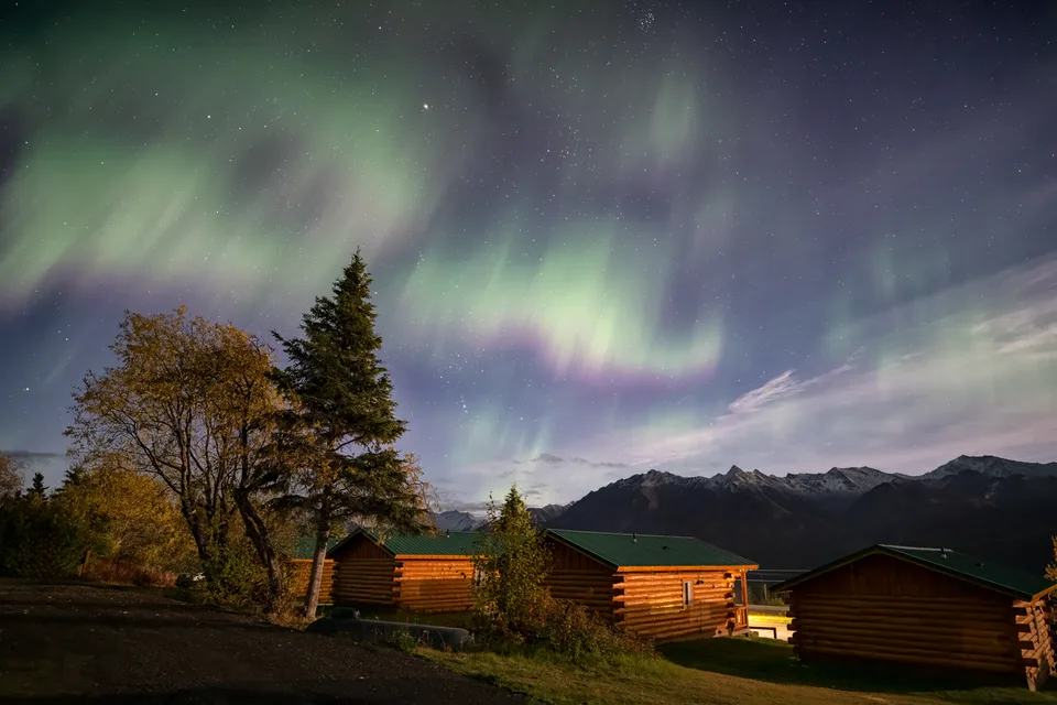 Aurora Over Cabins and Mountains